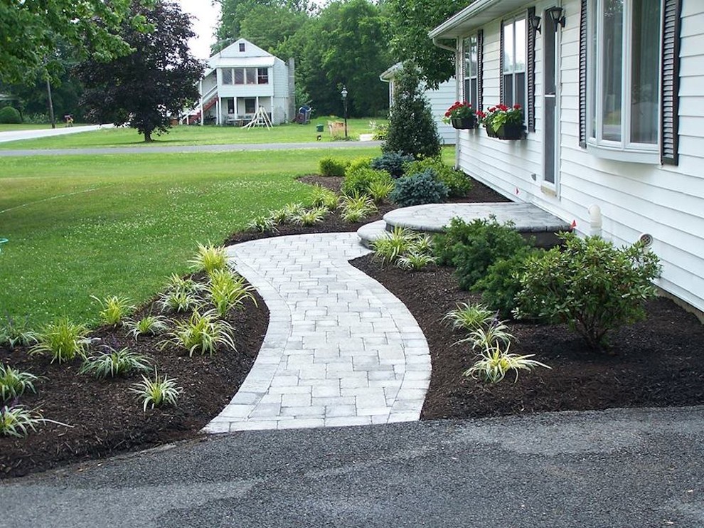 Photo of a large shade side yard concrete paver garden path.