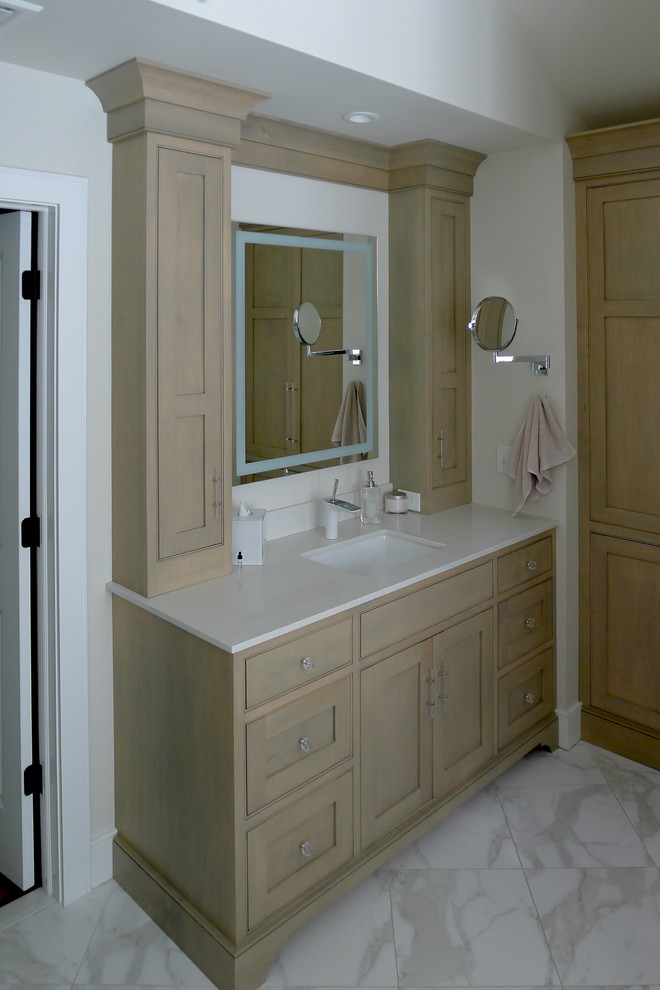Mid-sized traditional master bathroom in New York with shaker cabinets, beige cabinets, beige walls, marble floors, an undermount sink, solid surface benchtops and white floor.