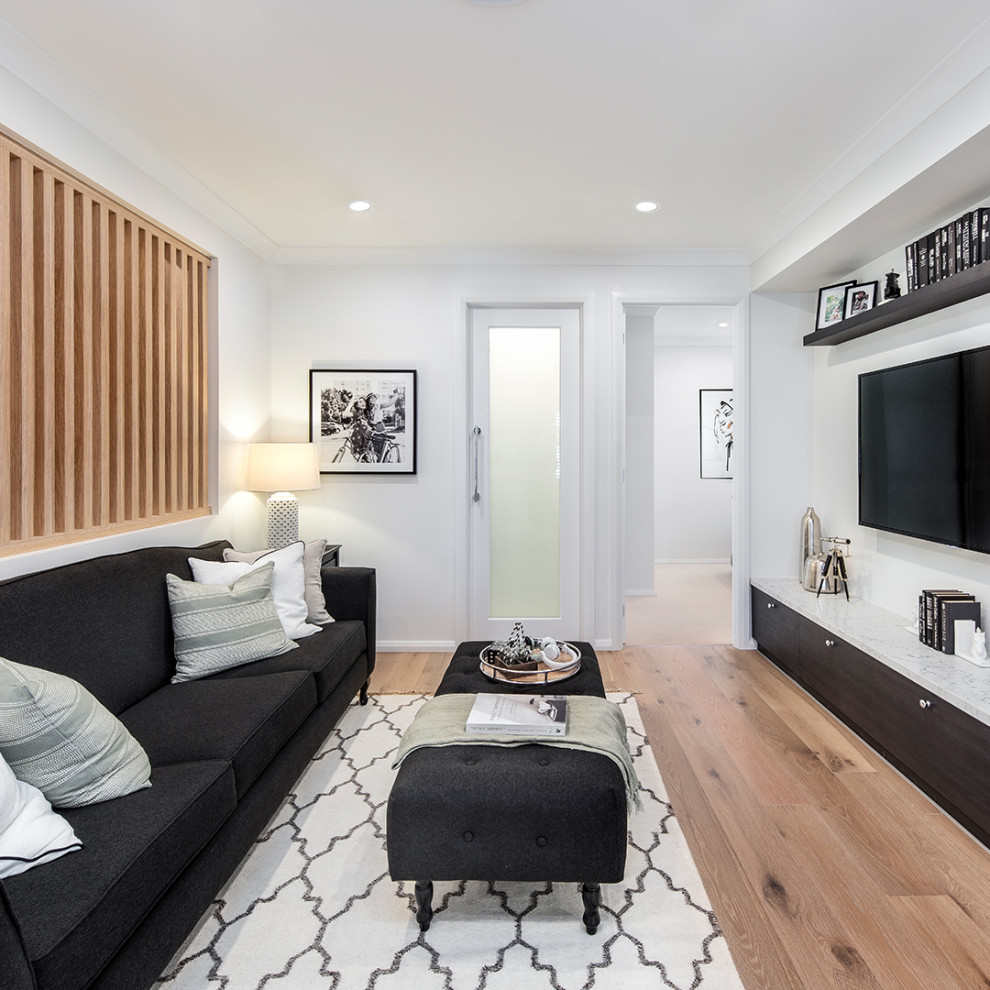 This is an example of a mid-sized traditional enclosed home theatre in Sydney with white walls, medium hardwood floors and a wall-mounted tv.