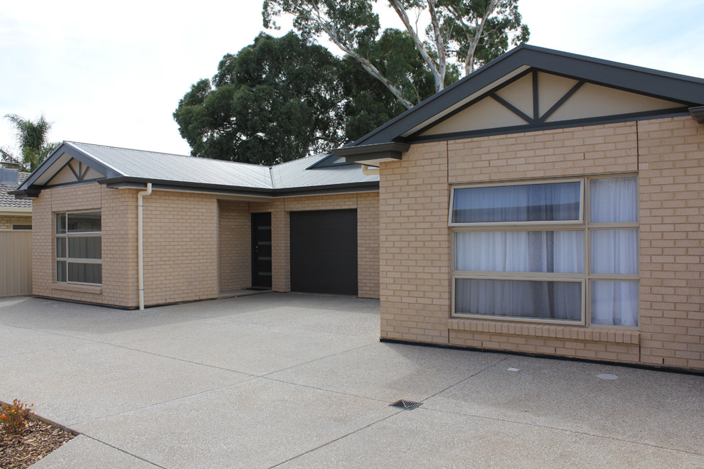Photo of a small traditional one-storey brick beige duplex exterior in Adelaide with a hip roof, a metal roof and a grey roof.