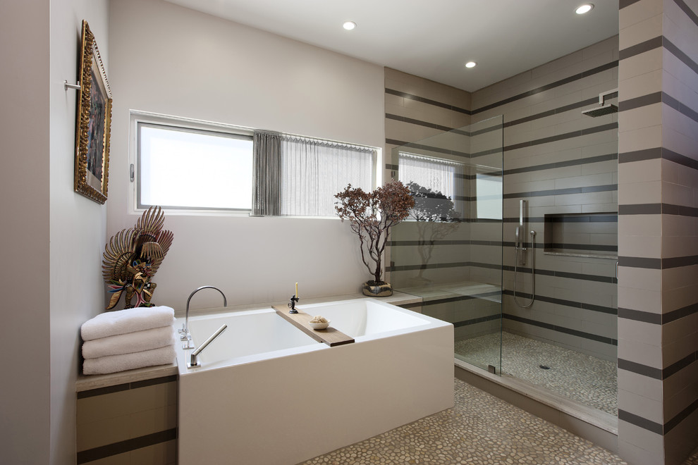 Photo of a contemporary bathroom in Los Angeles with a freestanding tub and pebble tile floors.