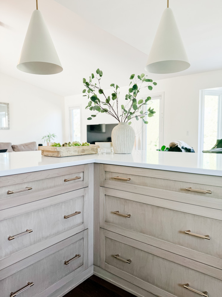 Inspiration för mellanstora moderna vitt kök, med en undermonterad diskho, skåp i shakerstil, gröna skåp, bänkskiva i kvarts, vitt stänkskydd, stänkskydd i keramik, rostfria vitvaror, mellanmörkt trägolv, en köksö och brunt golv