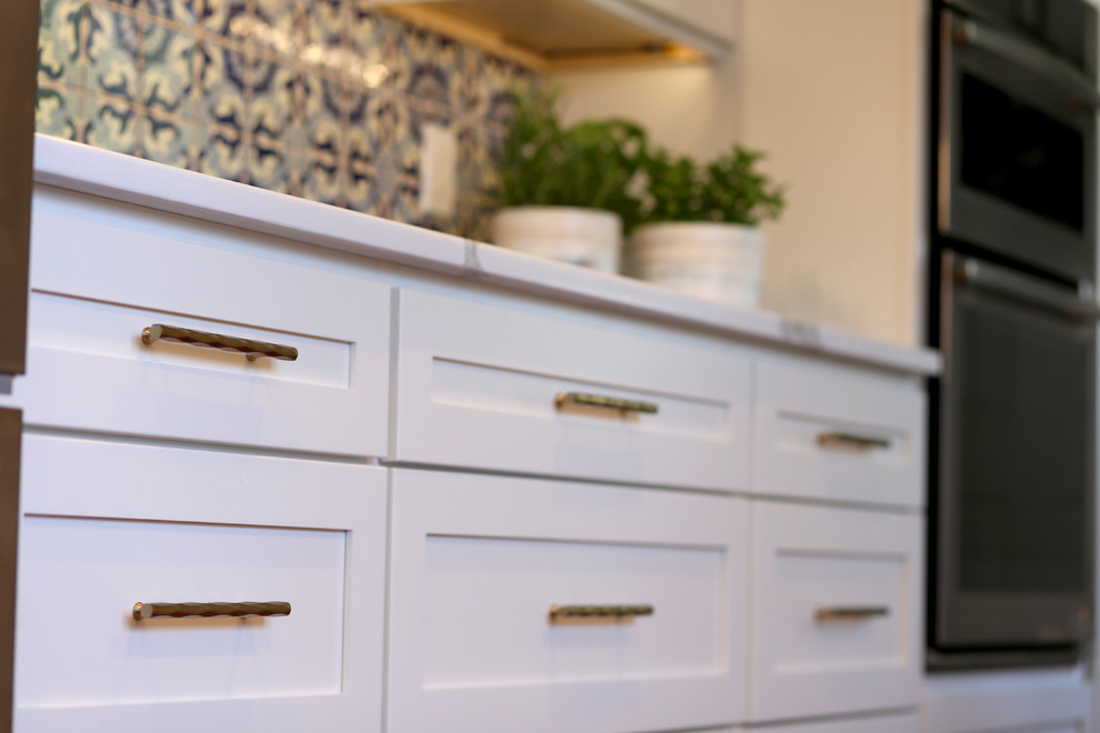 Inspiration for an eclectic dark wood floor and brown floor eat-in kitchen remodel in Denver with shaker cabinets, white cabinets, quartz countertops, blue backsplash, ceramic backsplash, stainless steel appliances and a peninsula