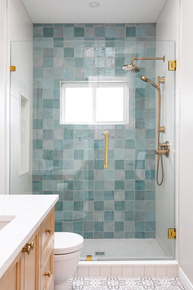 Bild på ett mellanstort funkis vit vitt badrum med dusch, med skåp i shakerstil, bruna skåp, en dusch i en alkov, blå kakel, porslinskakel, vita väggar, ett undermonterad handfat, bänkskiva i kvarts och dusch med gångjärnsdörr