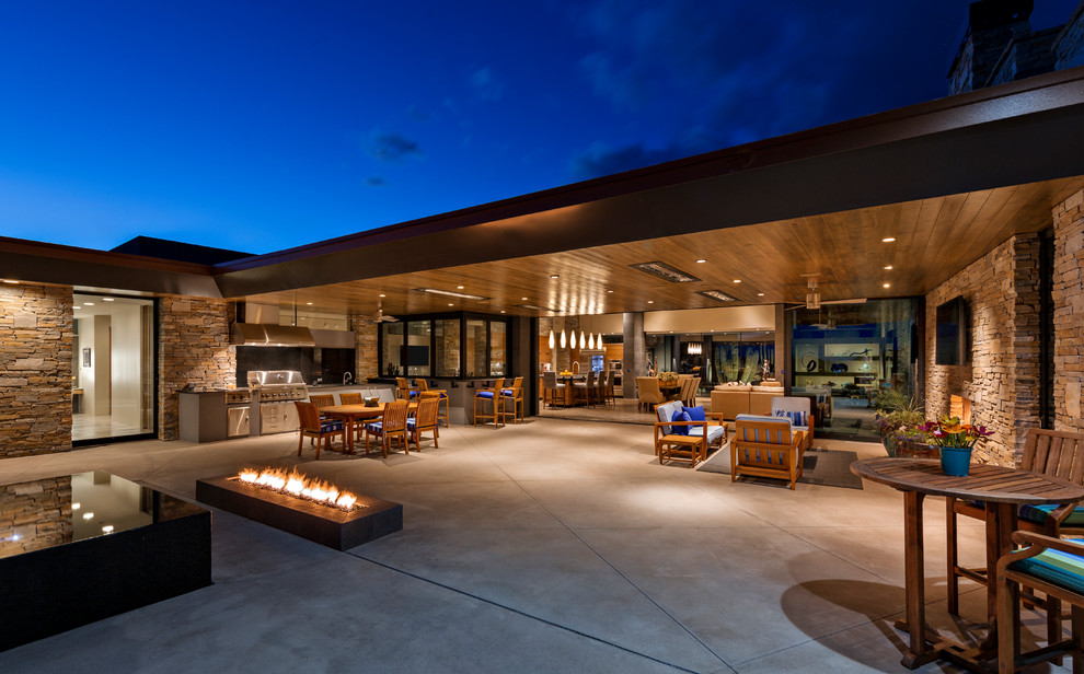 Inspiration for a contemporary backyard patio in Other with an outdoor kitchen, concrete slab and a roof extension.