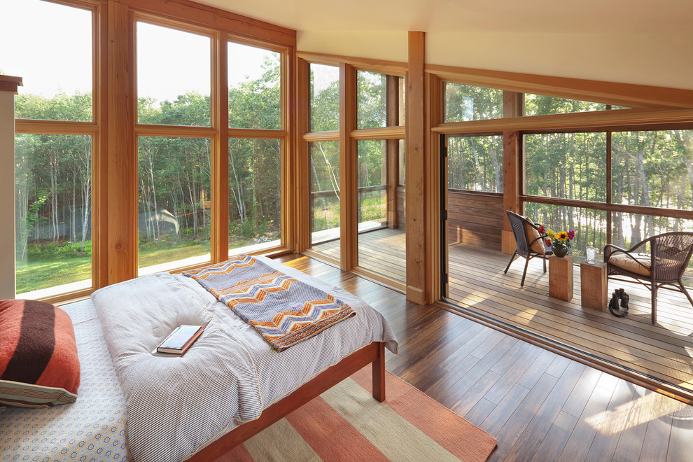 This is an example of a contemporary master bedroom in Portland Maine with medium hardwood floors.