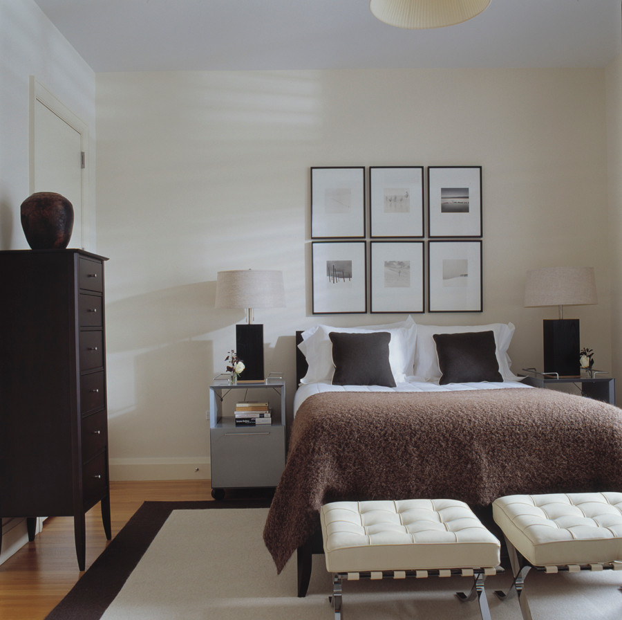 This is an example of a mid-sized modern loft-style bedroom in New York with white walls, light hardwood floors and no fireplace.