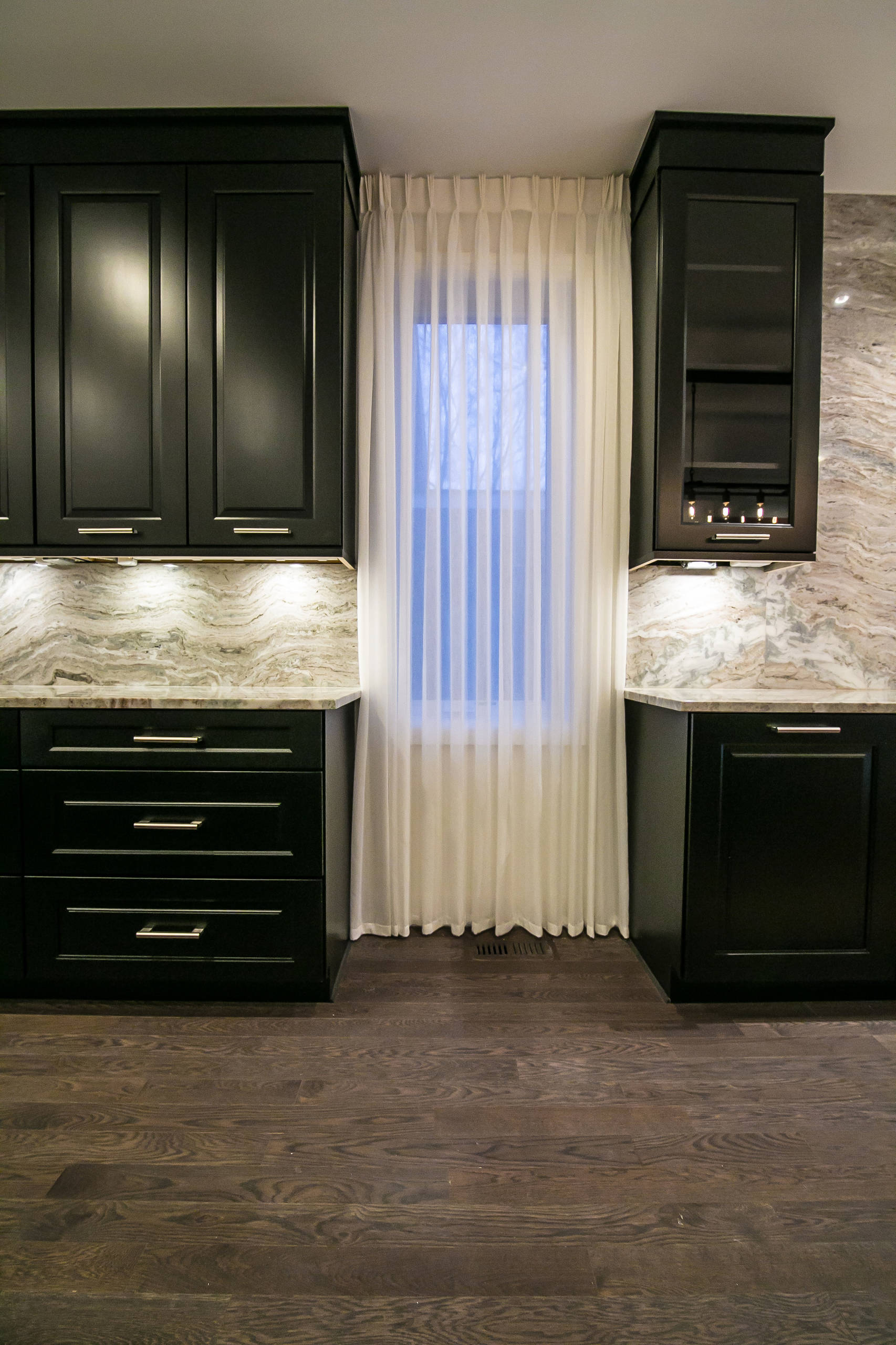 The desire for a modern, yet luxurious, aesthetic inspired a specific attention to detail and material for this home in Huntington Woods. Custom black cabinetry, Fantasy Brown quartzite and stainless