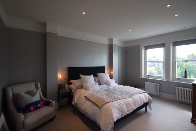 Mid-sized contemporary master bedroom in London with grey walls, grey floor and carpet.