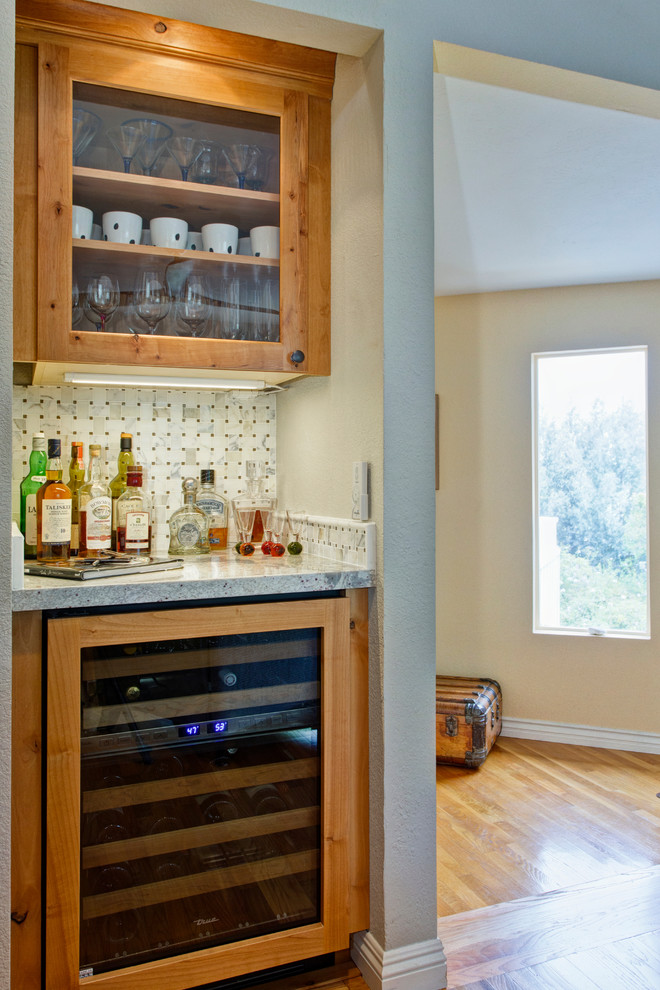 Small transitional l-shaped home bar in San Diego with an undermount sink, recessed-panel cabinets, white cabinets, granite benchtops, white splashback, mosaic tile splashback and medium hardwood floors.