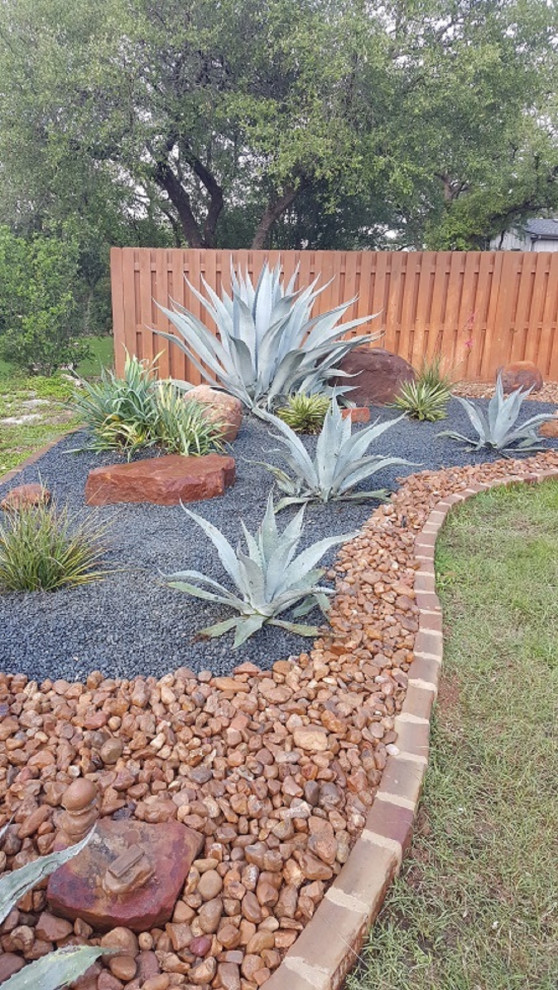Inspiration for a large contemporary backyard full sun xeriscape in Austin with with rock feature and river rock.