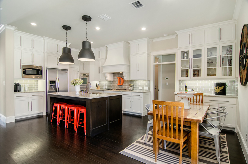Inspiration for a traditional l-shaped eat-in kitchen in Dallas with shaker cabinets, white cabinets, grey splashback, subway tile splashback, stainless steel appliances, dark hardwood floors and with island.