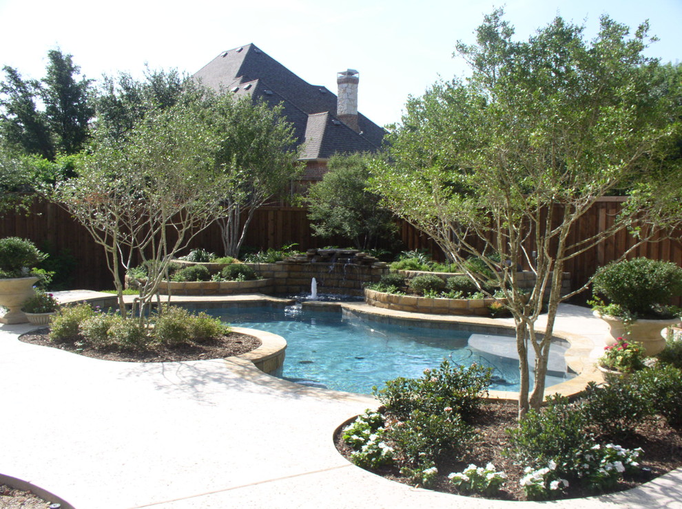 Design ideas for a mid-sized backyard custom-shaped natural pool in Dallas with a water feature and decking.