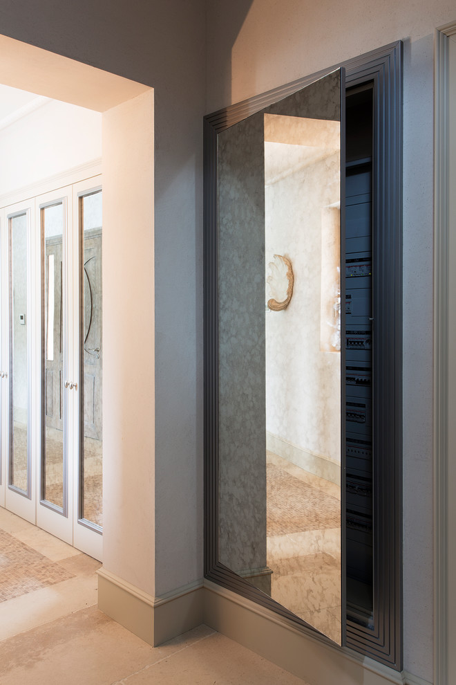 Photo of an expansive traditional gender-neutral built-in wardrobe in Nice with glass-front cabinets, grey cabinets and beige floor.