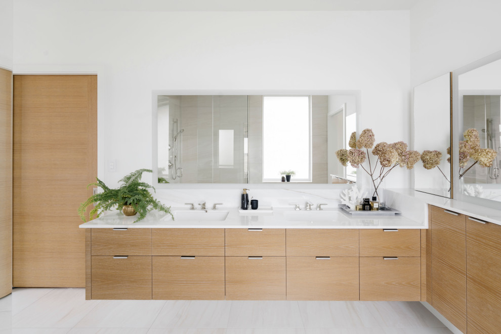 Large contemporary master bathroom in Calgary with flat-panel cabinets, light wood cabinets, a corner shower, a wall-mount toilet, beige tile, porcelain tile, white walls, porcelain floors, an undermount sink, marble benchtops, beige floor, a hinged shower door, white benchtops, a shower seat, a double vanity and a floating vanity.