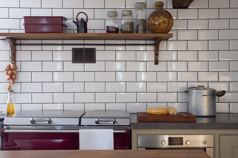 This is an example of a small traditional l-shaped separate kitchen in Gloucestershire with a farmhouse sink, grey cabinets, concrete benchtops, white splashback, subway tile splashback, stainless steel appliances, limestone floors, with island and beaded inset cabinets.