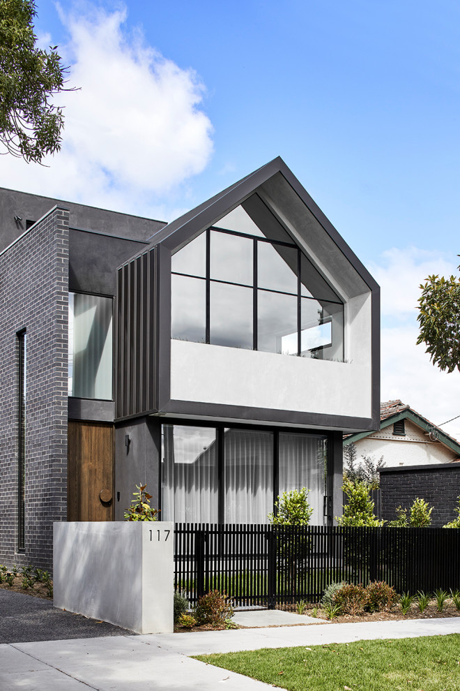 Mittelgroßes, Dreistöckiges Modernes Reihenhaus mit Backsteinfassade, bunter Fassadenfarbe, Flachdach, Blechdach und schwarzem Dach in Melbourne