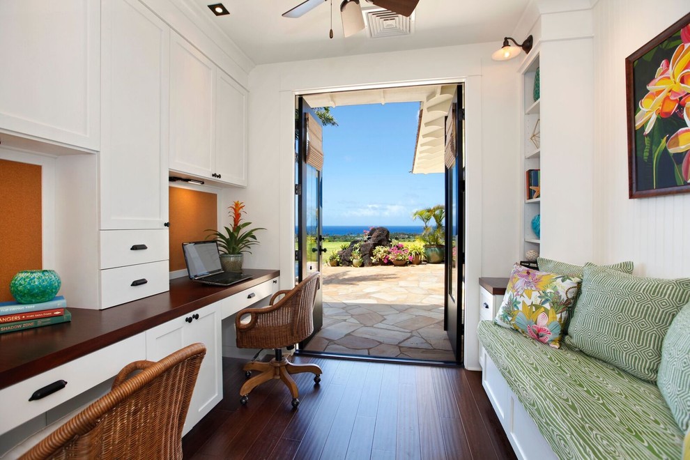 This is an example of a mid-sized beach style study room in Hawaii with white walls, bamboo floors, a built-in desk, black floor and no fireplace.