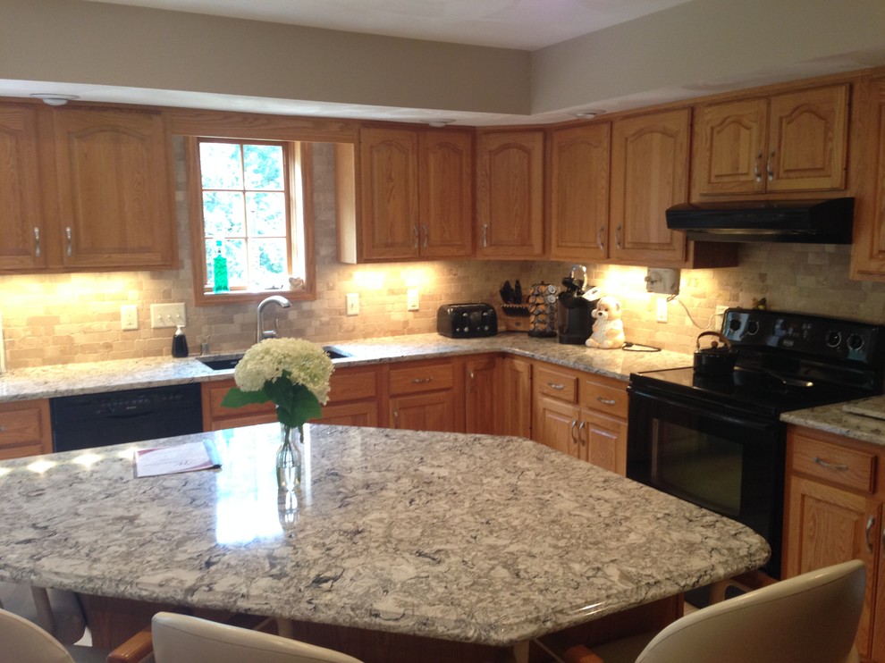 Example of a mid-sized l-shaped medium tone wood floor kitchen design with a double-bowl sink, raised-panel cabinets, medium tone wood cabinets, quartz countertops, beige backsplash, black appliances and an island