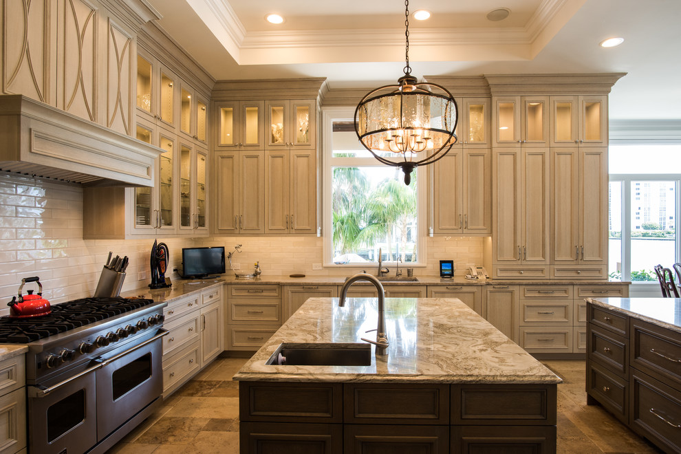 Inspiration for a large transitional u-shaped travertine floor and beige floor kitchen remodel with an undermount sink, raised-panel cabinets, brown cabinets, quartzite countertops, white backsplash, subway tile backsplash, paneled appliances and two islands