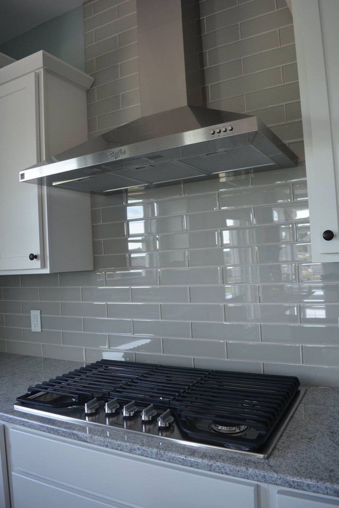 Open concept kitchen - large transitional l-shaped dark wood floor open concept kitchen idea with an undermount sink, shaker cabinets, white cabinets, granite countertops, gray backsplash, porcelain backsplash, stainless steel appliances and an island
