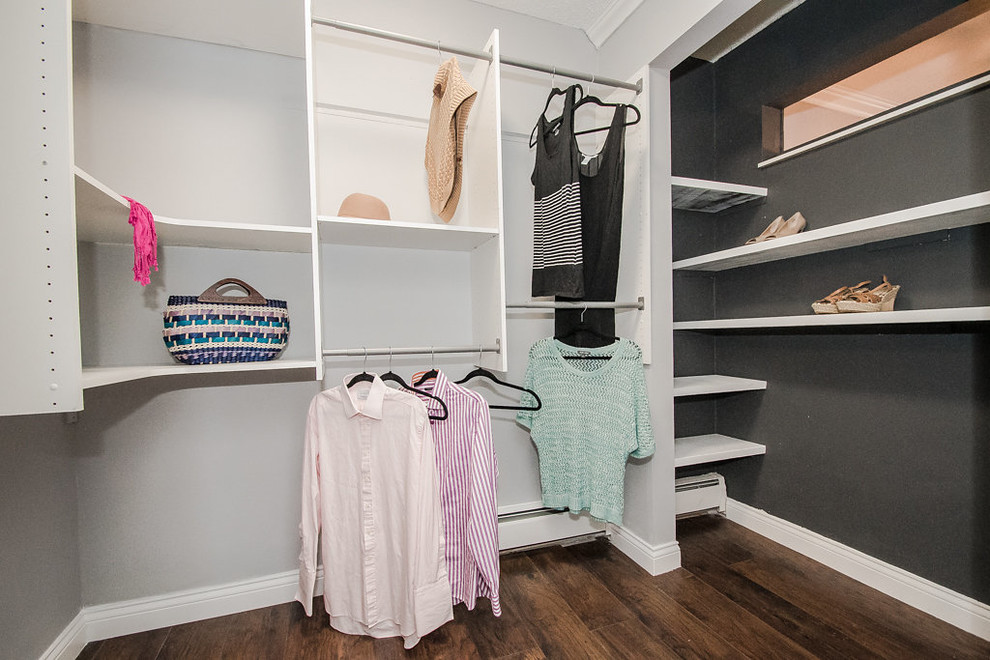 This is an example of a small contemporary gender-neutral walk-in wardrobe in Minneapolis with laminate floors and brown floor.
