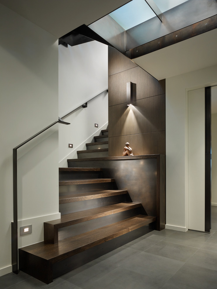 This is an example of a contemporary wood staircase in Seattle with metal risers.