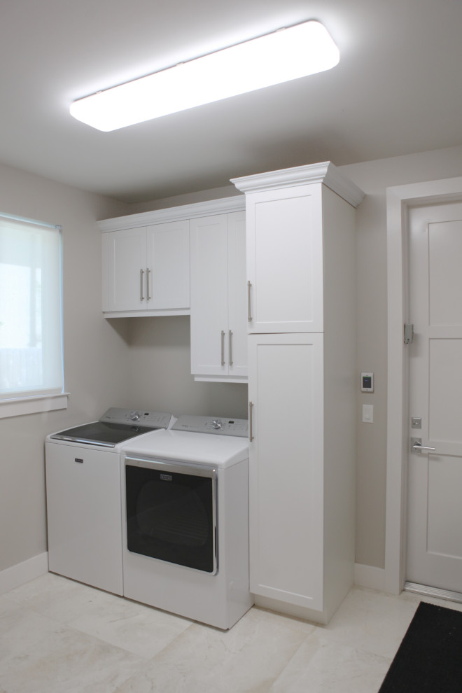 Inspiration for a mid-sized single-wall dedicated laundry room in Miami with flat-panel cabinets, white cabinets, white walls, ceramic floors, a side-by-side washer and dryer and beige floor.