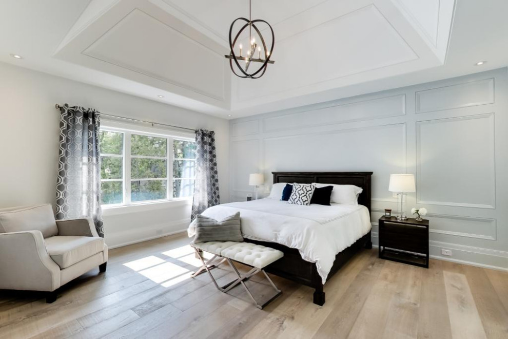 Imagen de dormitorio principal y abovedado tradicional renovado grande con paredes grises, suelo de madera clara, suelo marrón y boiserie