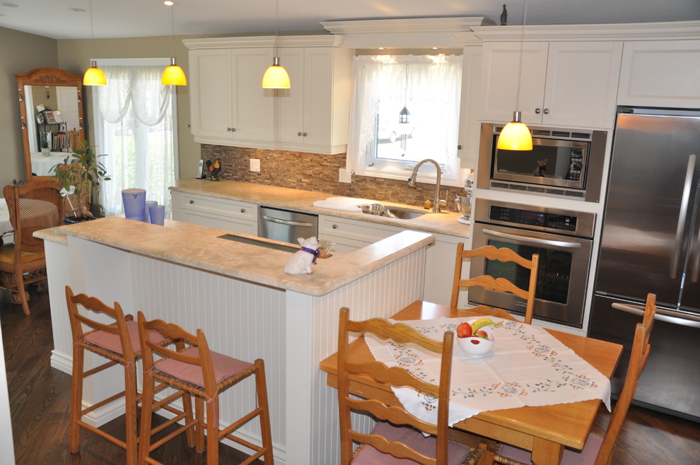 Large mountain style single-wall dark wood floor eat-in kitchen photo in Ottawa with an undermount sink, shaker cabinets, beige cabinets, granite countertops, brown backsplash, stone tile backsplash, stainless steel appliances and an island