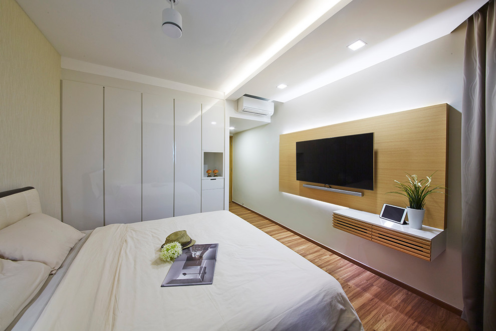 Inspiration for a large modern master bedroom in Singapore with white walls and light hardwood floors.
