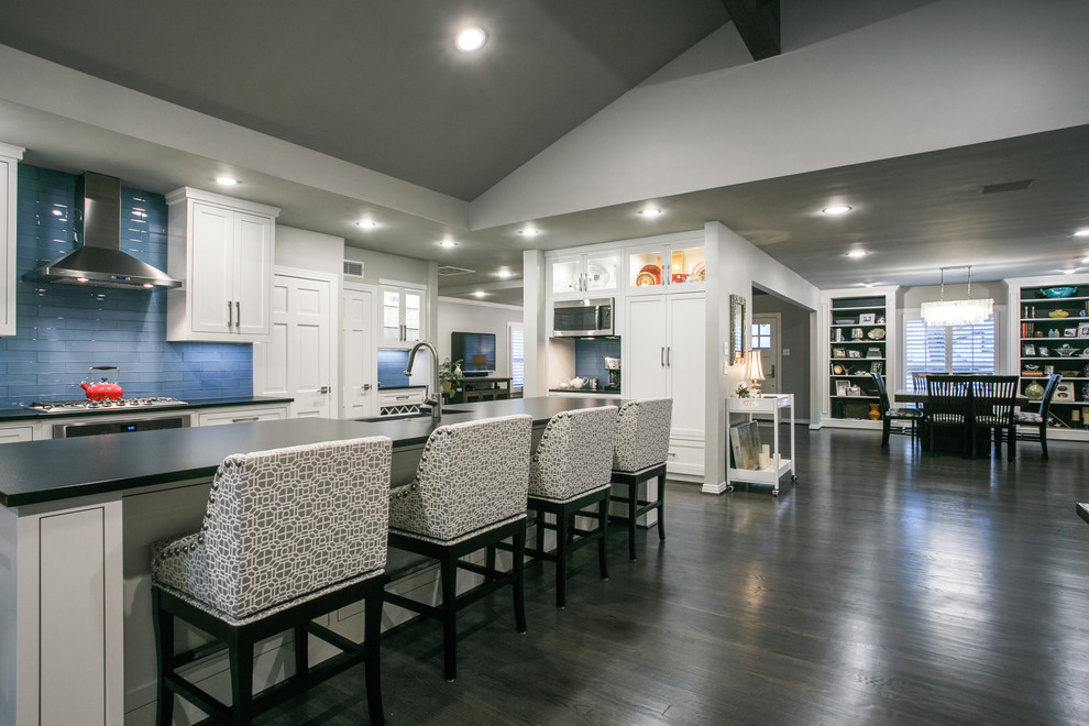 Photo of a large transitional l-shaped open plan kitchen in Dallas with a farmhouse sink, shaker cabinets, white cabinets, quartz benchtops, blue splashback, subway tile splashback, stainless steel appliances, dark hardwood floors and with island.