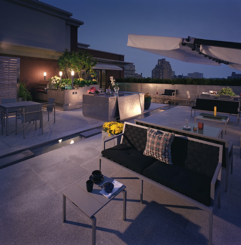This is an example of a large contemporary backyard patio in Toronto with an outdoor kitchen, concrete pavers and no cover.