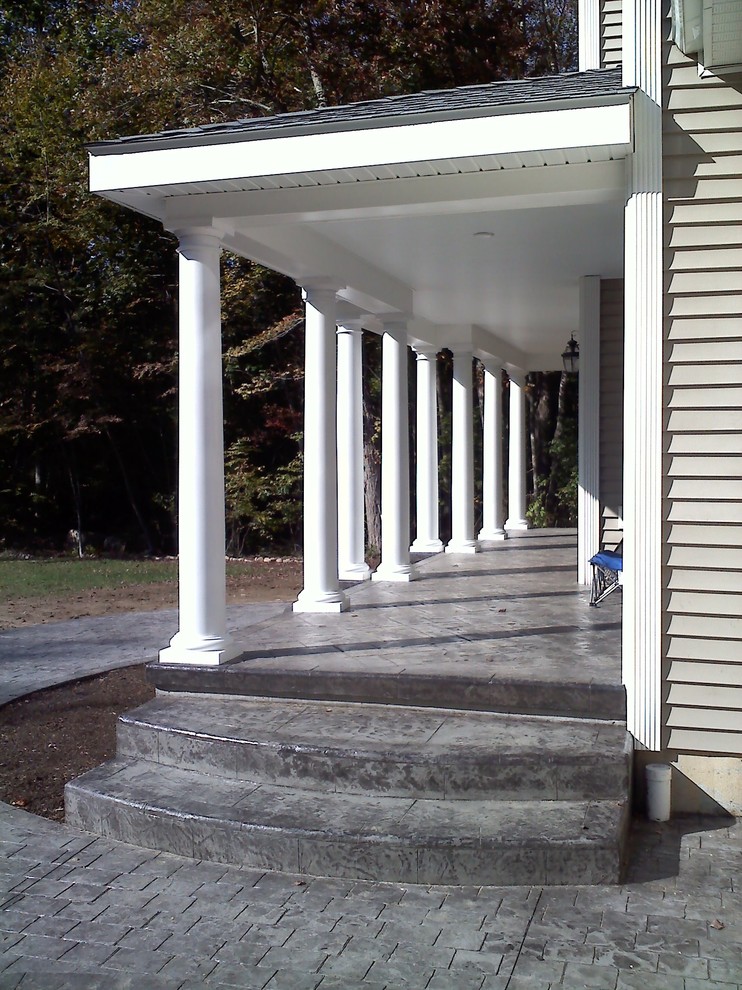 Photo of a traditional front yard verandah in Bridgeport with stamped concrete and a roof extension.