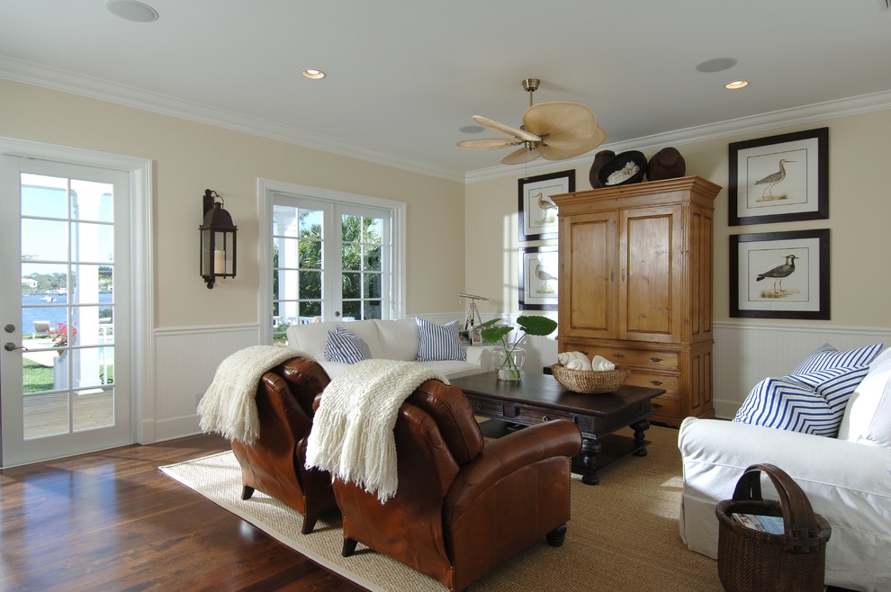 Photo of a mid-sized beach style open concept family room in Miami with beige walls, dark hardwood floors and a concealed tv.