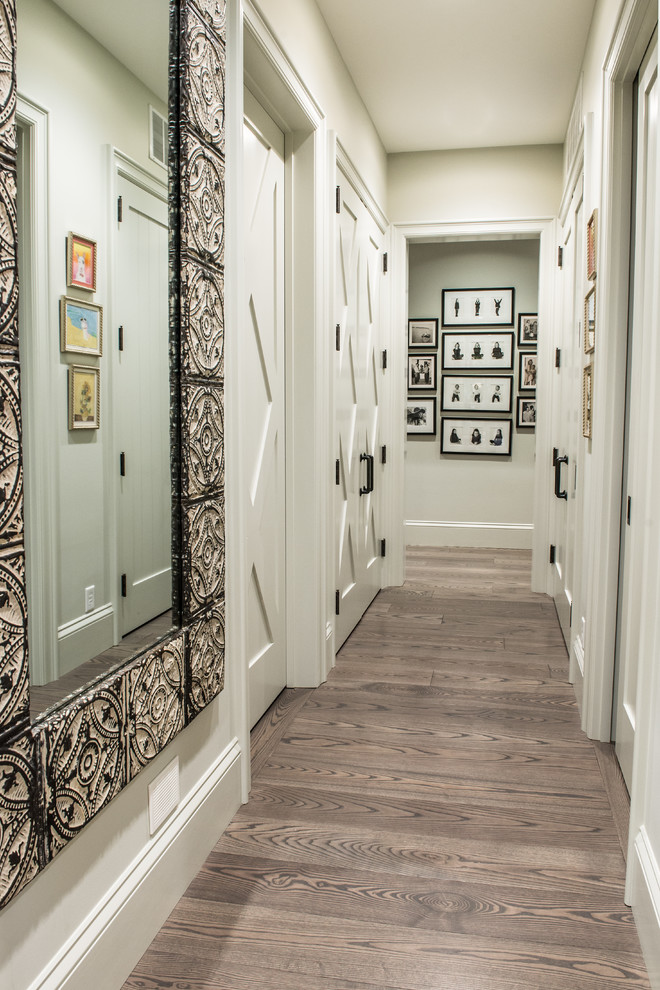 This is an example of a mid-sized country hallway in St Louis with beige walls and light hardwood floors.
