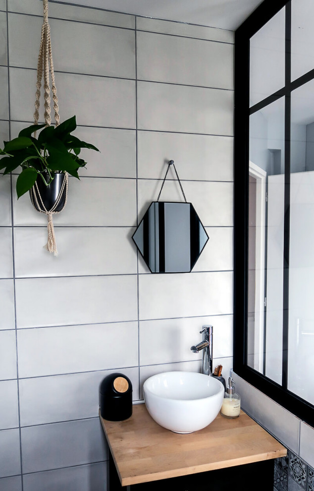 Idée de décoration pour une petite salle d'eau grise et noire avec un placard sans porte, une baignoire posée, un carrelage gris, des carreaux de béton, un mur gris, un sol en carrelage imitation parquet, un sol marron, meuble simple vasque et meuble-lavabo sur pied.