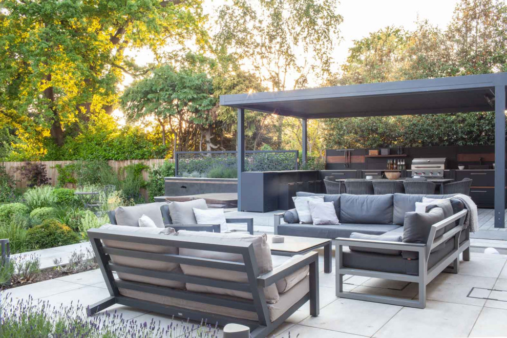 Photo of a medium sized contemporary back ground level terrace in Surrey with an outdoor kitchen and a pergola.
