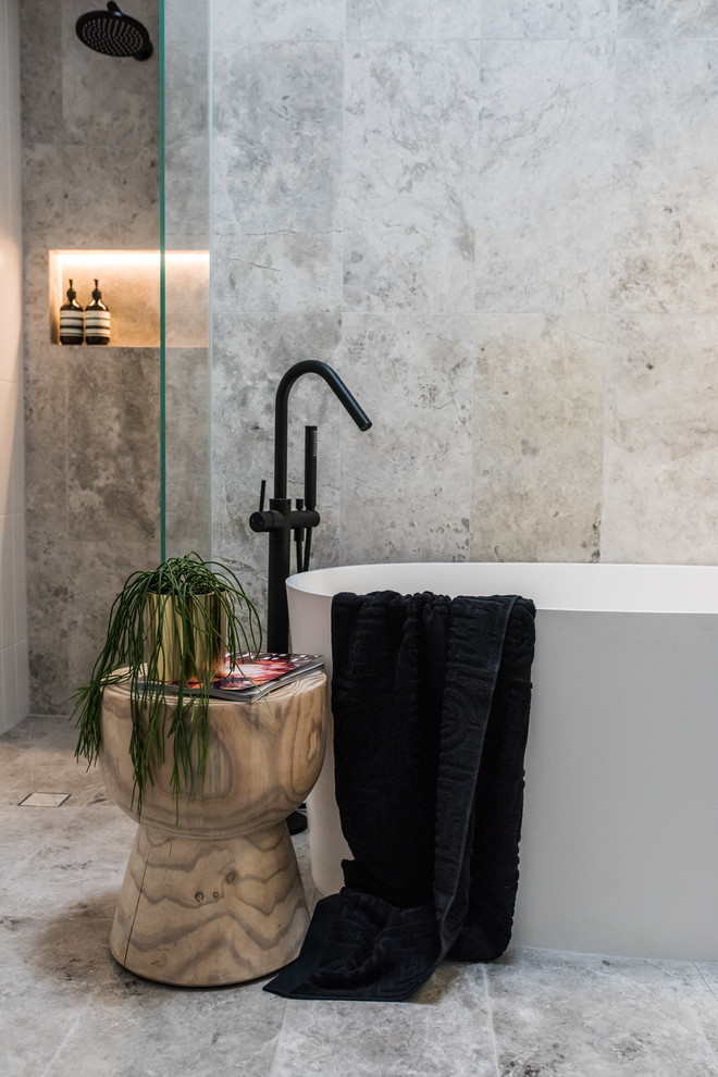 Photo of a mid-sized contemporary master bathroom in Melbourne with furniture-like cabinets, grey cabinets, a freestanding tub, an open shower, a one-piece toilet, white tile, marble, grey walls, marble floors, a vessel sink, marble benchtops, grey floor and a hinged shower door.