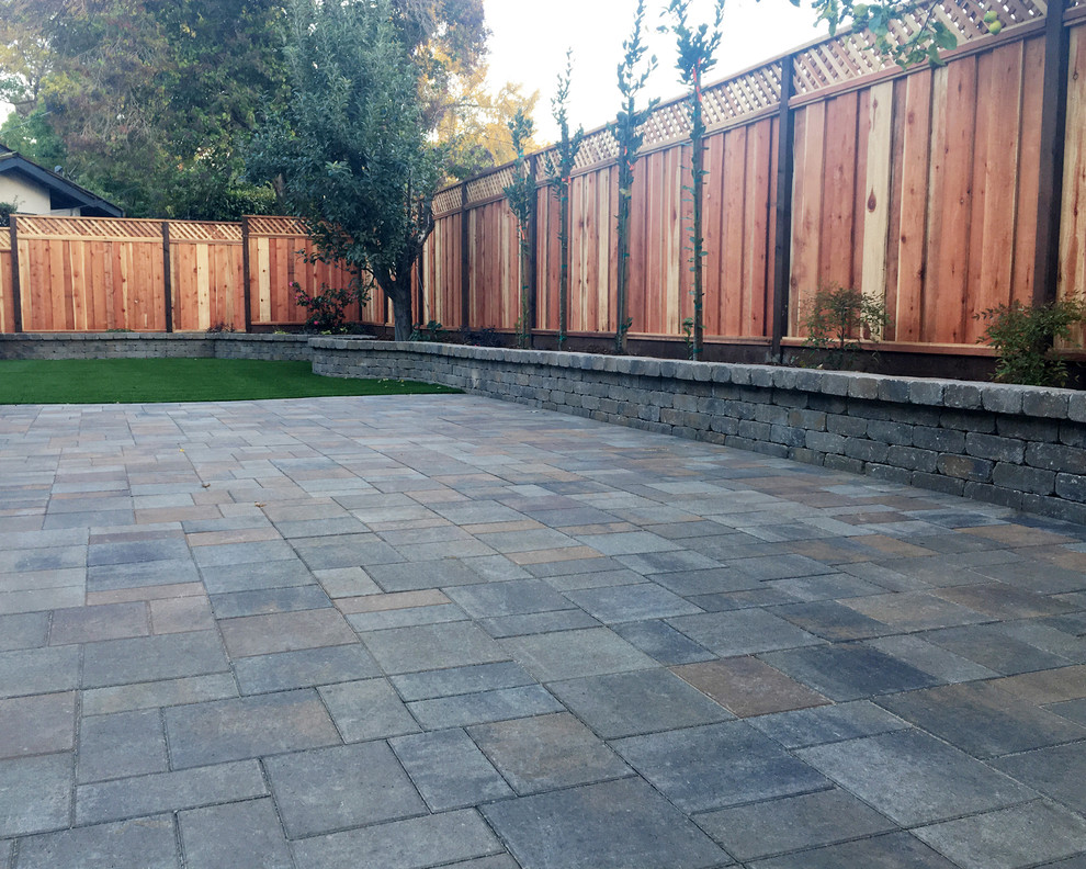 Inspiration for a mid-sized traditional backyard partial sun formal garden for summer in San Francisco with concrete pavers and a retaining wall.