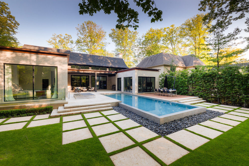 Large trendy backyard stone and rectangular infinity pool fountain photo