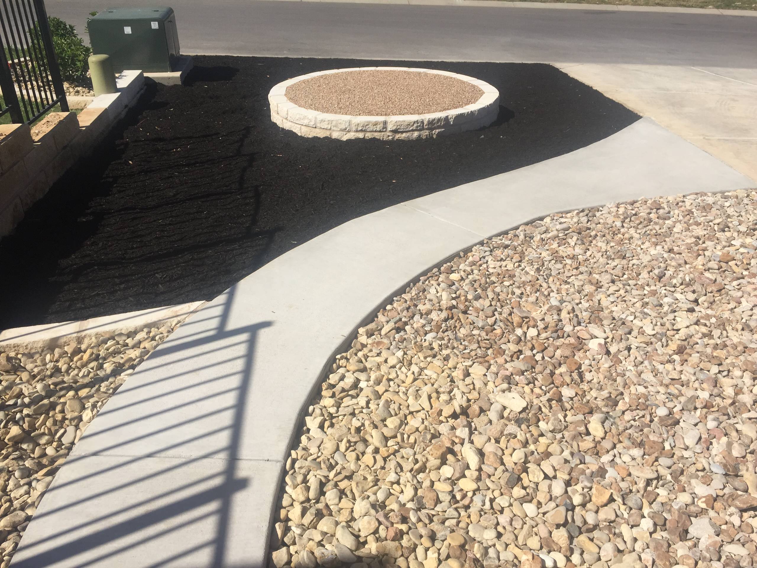 New concrete sidewalk & limestone raised bed w/ different gravels