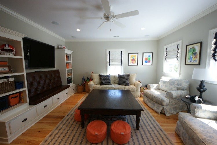 This is an example of a mid-sized traditional enclosed living room in Charleston with grey walls, medium hardwood floors and a wall-mounted tv.