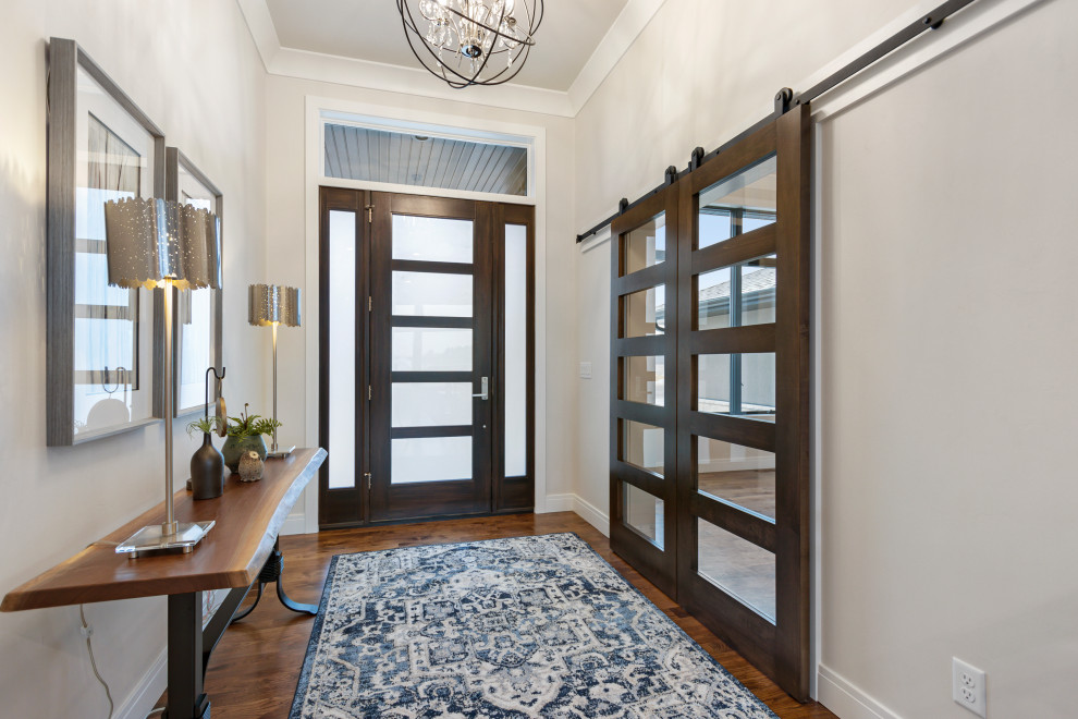 Example of a mid-sized transitional medium tone wood floor and brown floor foyer design with white walls and a brown front door