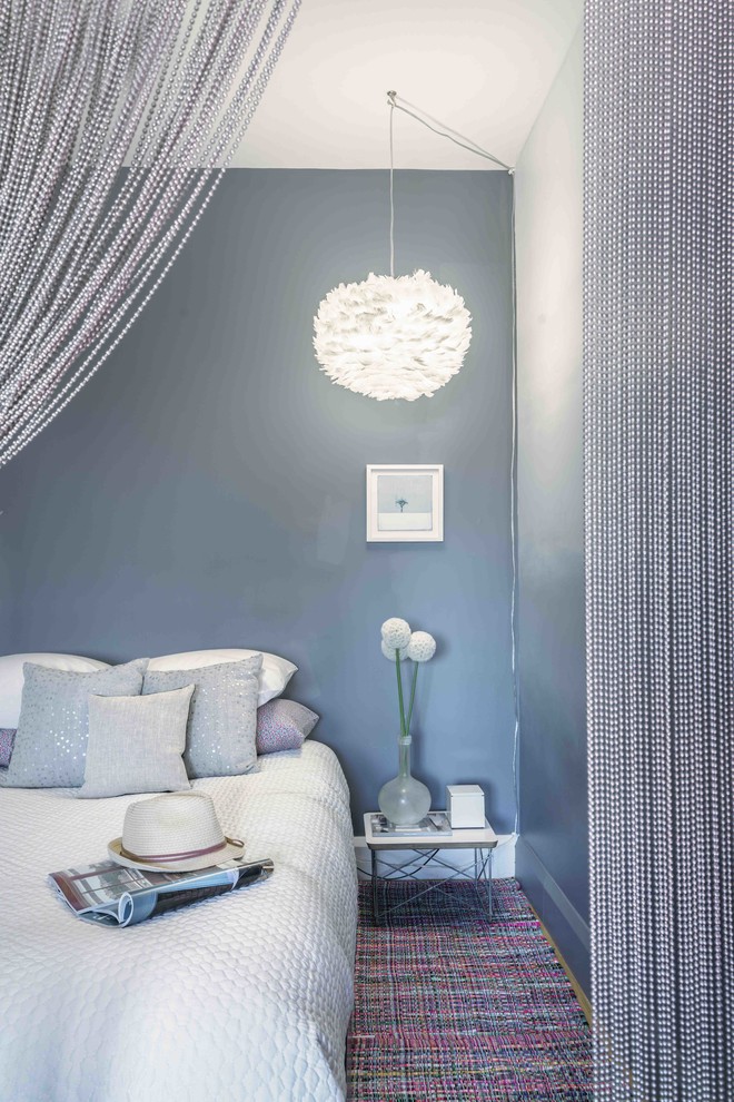 Example of a small trendy master light wood floor and beige floor bedroom design in New York with gray walls and no fireplace