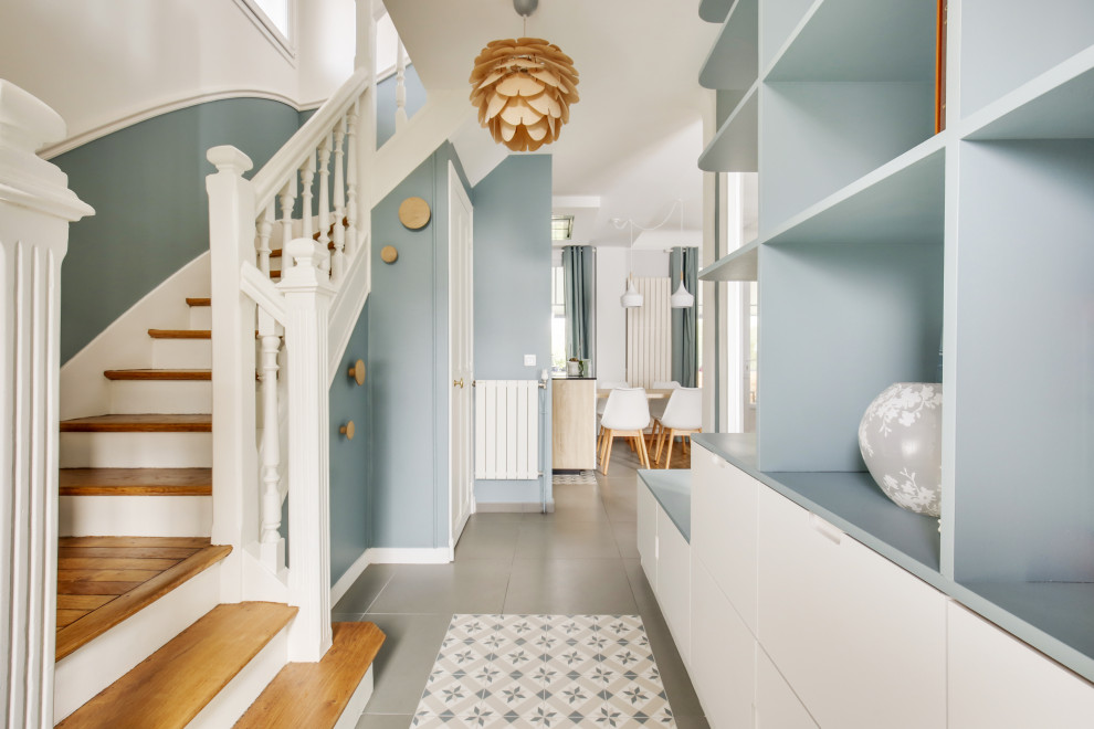 Photo of a small scandinavian hallway in Paris with blue walls, ceramic flooring, a single front door, a white front door, multi-coloured floors and wainscoting.
