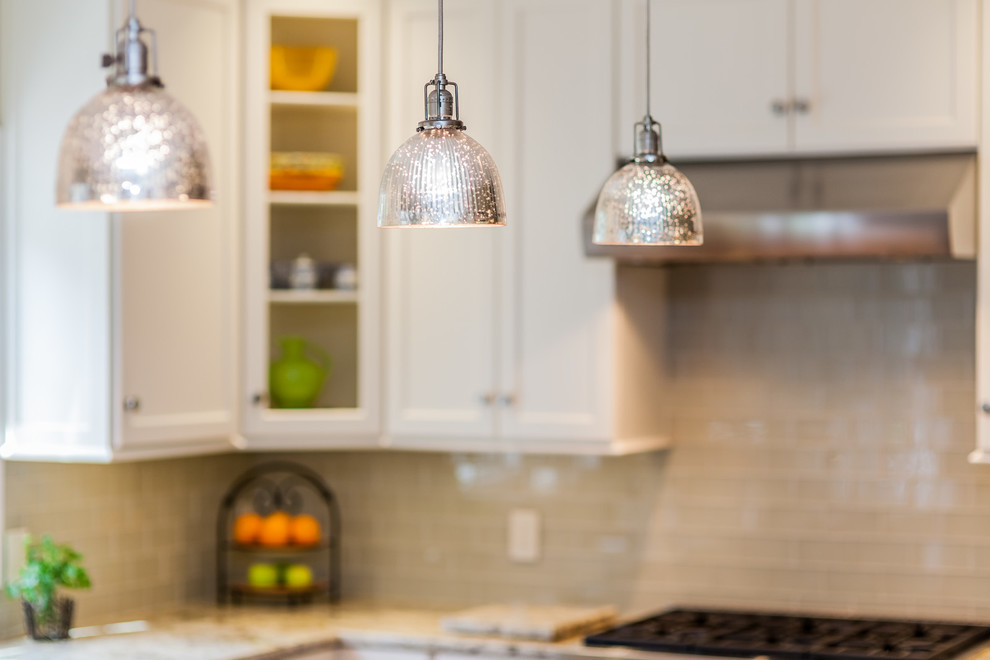 Example of a mid-sized transitional l-shaped light wood floor eat-in kitchen design in Boston with an undermount sink, recessed-panel cabinets, white cabinets, granite countertops, gray backsplash, glass tile backsplash, stainless steel appliances and an island