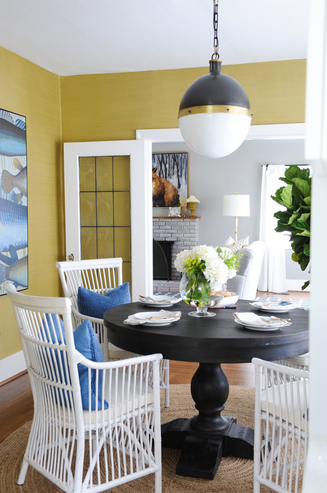 This is an example of a beach style dining room in Other with yellow walls, medium hardwood floors and brown floor.