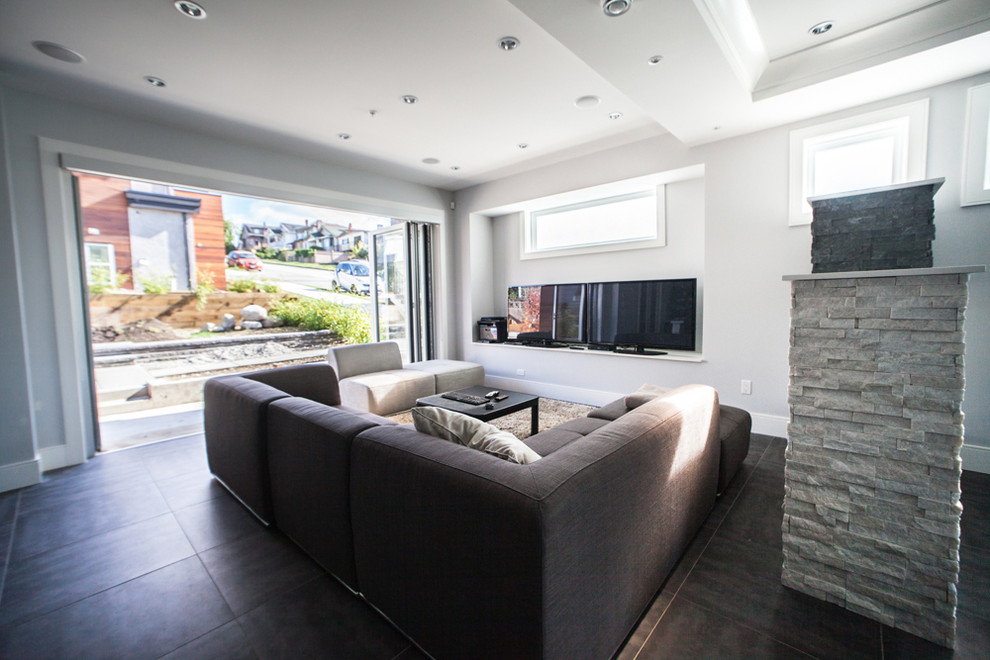 Large contemporary open concept family room in Vancouver with grey walls, laminate floors, a two-sided fireplace, a stone fireplace surround, a freestanding tv and brown floor.