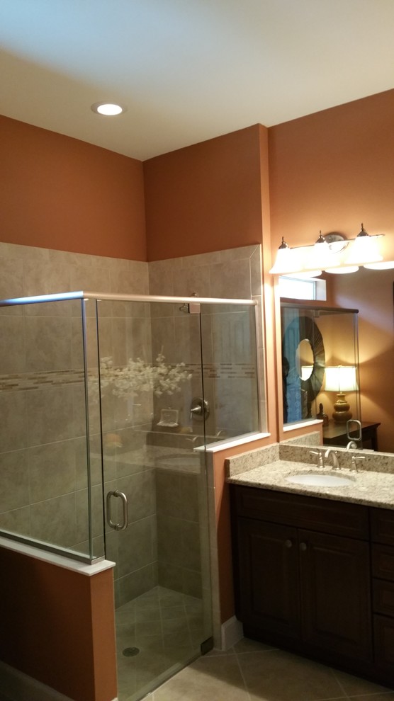 Mid-sized transitional master beige tile and ceramic tile dark wood floor corner shower photo in Miami with recessed-panel cabinets, dark wood cabinets, yellow walls, an undermount sink and granite countertops
